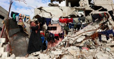 A displaced Palestinian who lives amongst the rubble and debris of homes and businesses destroyed by the Israeli military in over two years of military strikes on the Gaza Strip enclave, hangs out the laundry in Jabalia refugee camp, Gaza Strip, Palestine, Jan. 17, 2026. (AFP Photo)
