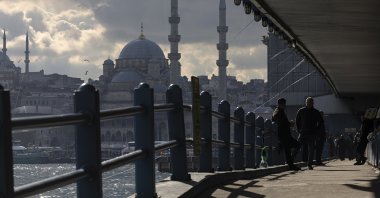 People cross the Galata Bridge backdropped by a cloudy sky, over the Golden Horn in Istanbul, Türkiye, Jan. 13, 2026. (EPA Photo)