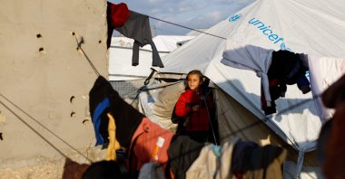 A child looks out from a tent as displaced Palestinians shelter in a tent camp in Deir al-Balah, central Gaza Strip, Jan. 19, 2026. (Reuters Photo)