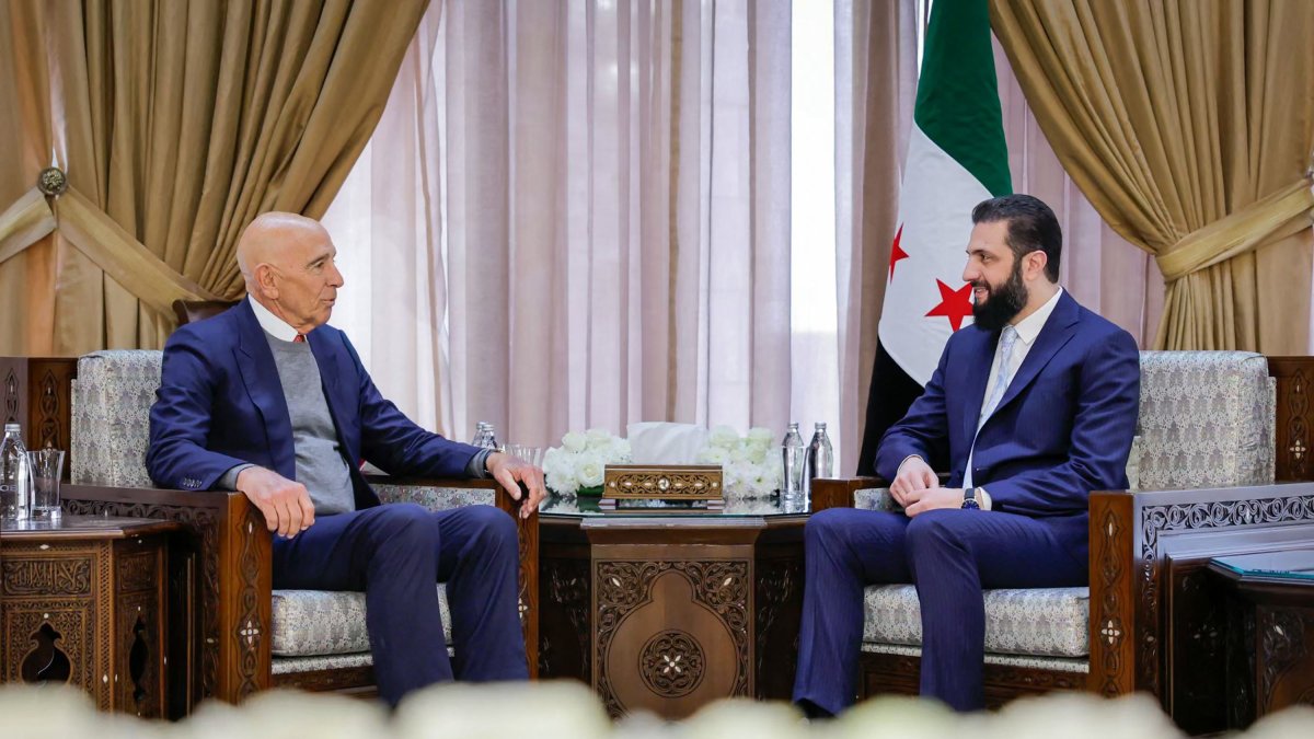 This handout picture released by the Syrian Presidency's Telegram page, shows Syria's President Ahmed al-Sharaa meeting with US envoy Tom Barrack at the Presidential Palace in Damascus, Jan. 18, 2026. (Photo by Handout / Syrian Presidency Telegram Page / AFP) 