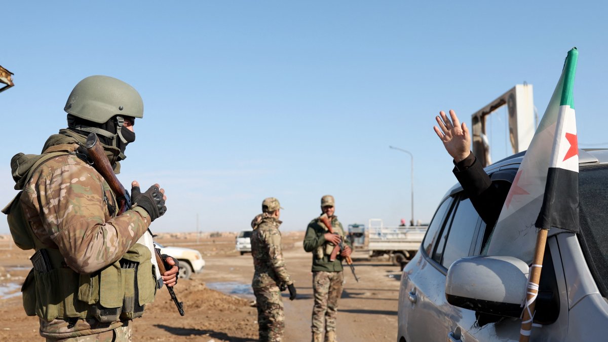 A resident waves as Syrian government forces man a checkpoint after entering the city of Ash Shaddadah south of the city of Hasakeh in northeastern Syria, Jan. 20, 2026. (AFP Photo)