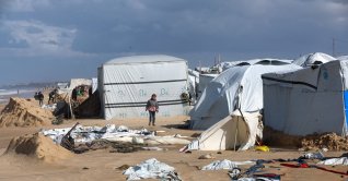 A displaced Palestinian child walks among damaged tents at a beach tent camp, after it was flooded by rising seawater during a winter storm in Khan Younis, southern Gaza Strip, Dec. 28, 2025. (Reuters Photo)