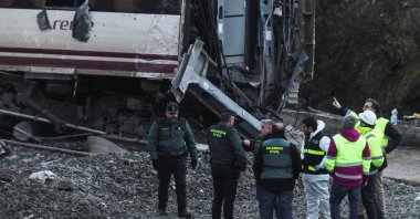 Members of the Spanish Civil Guard and ADIF stand near the wreckage of a train involved in the accident, at the site of a deadly derailment of two high-speed trains near Adamuz, Cordoba, Spain, Jan. 20, 2026. (Reuters Photo)