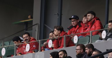 Short track Olympic hopefuls Furkan Akar (R) and Denis Örs (2nd R), part of Türkiye’s Milano-Cortina 2026 delegation, watch from the stands during the Turkish Cup match between Kocaelispor and Erzurumspor at Turka Araç Muayene Kocaeli Stadium, Kocaeli, Türkiye, Dec. 23, 2025. (AA Photo)