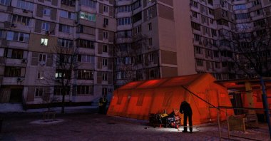 A State Emergency Service employee checks a generator next to a tent of a government-run humanitarian aid point installed next to apartment buildings during a power blackout after critical civil infrastructure was hit by overnight Russian missile and drone strikes, in Kyiv, Ukraine, Jan. 20, 2026. (Reuters Photo)