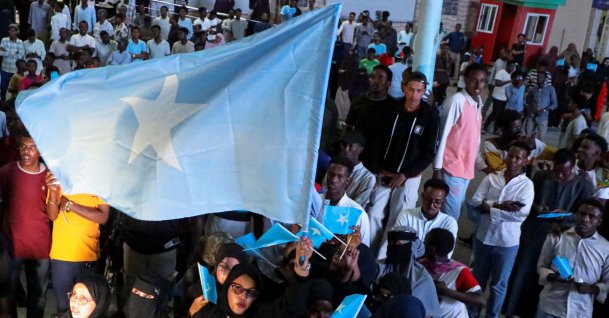 A woman holds a large Somali flag as Somalis attend a demonstration after Israel became the first country to formally recognize the self-declared Republic of Somaliland, Hodan district of Mogadishu, Somalia, Dec. 28, 2025. (Reuters Photo)