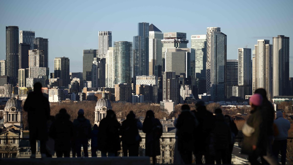 People visit a lookout point in Greenwich Park, with the Canary Wharf financial district in the distance, London, U.K., Jan. 2, 2026. (AFP Photo)