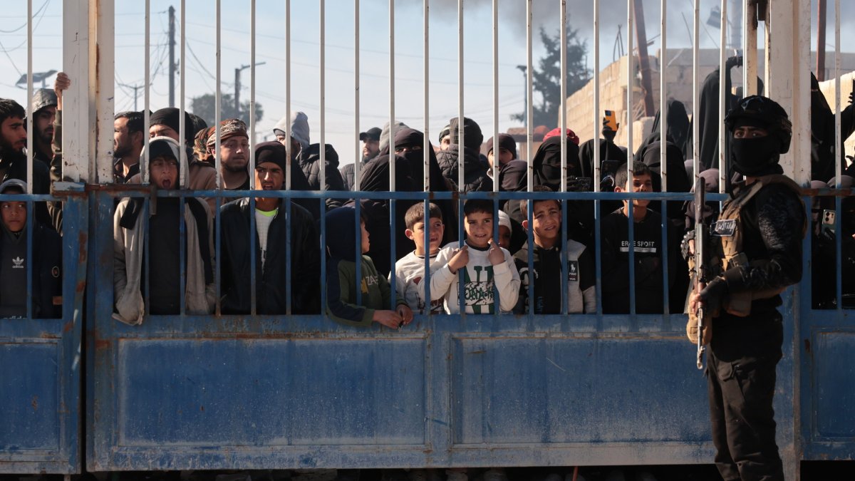 Members of the Syrian security forces stand in front of the gate of the AL-Hol camp, which houses families of suspected Daesh terrorists, after the Syrian government took control of the area, in Hasakah province, Syria, Jan. 21, 2026. (EPA Photo)