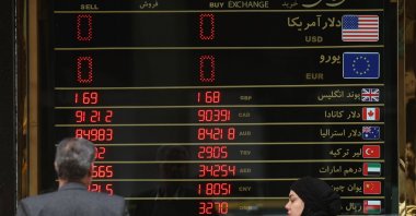 Iranians walk past a currency exchange shop, Tehran, Iran, Jan. 19, 2026. (EPA Photo)