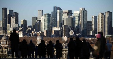 People visit a lookout point in Greenwich Park, with the Canary Wharf financial district in the distance, London, U.K., Jan. 2, 2026. (AFP Photo)