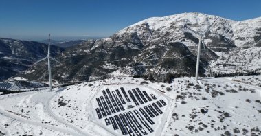 Solar panels and wind turbines are seen with a backdrop of the Amanos Mountains, Osmaniye, southern Türkiye, Jan. 3, 2026. (AA Photo)