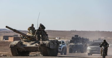 Soldiers ride on a tank as Syrian government forces make their way to the city of Hassakeh, Syria, Jan. 20, 2026. (AFP Photo)