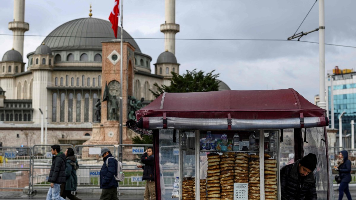 People pass next to a street vendor who sells traditional Turkish bagel "simit," Istanbul, Türkiye, Dec. 27, 2025. (AFP Photo)