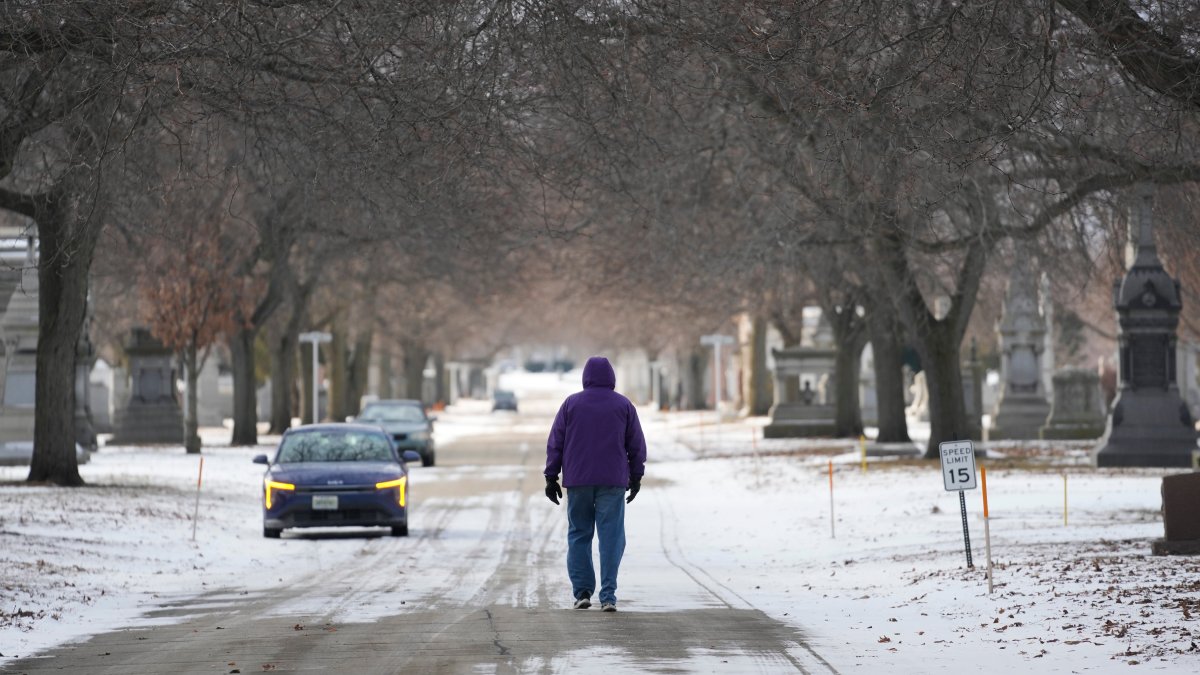 A person walks in a snowy Calvary Catholic Cemetery, Chicago, U.S., Jan. 21, 2026. (AP Photo)