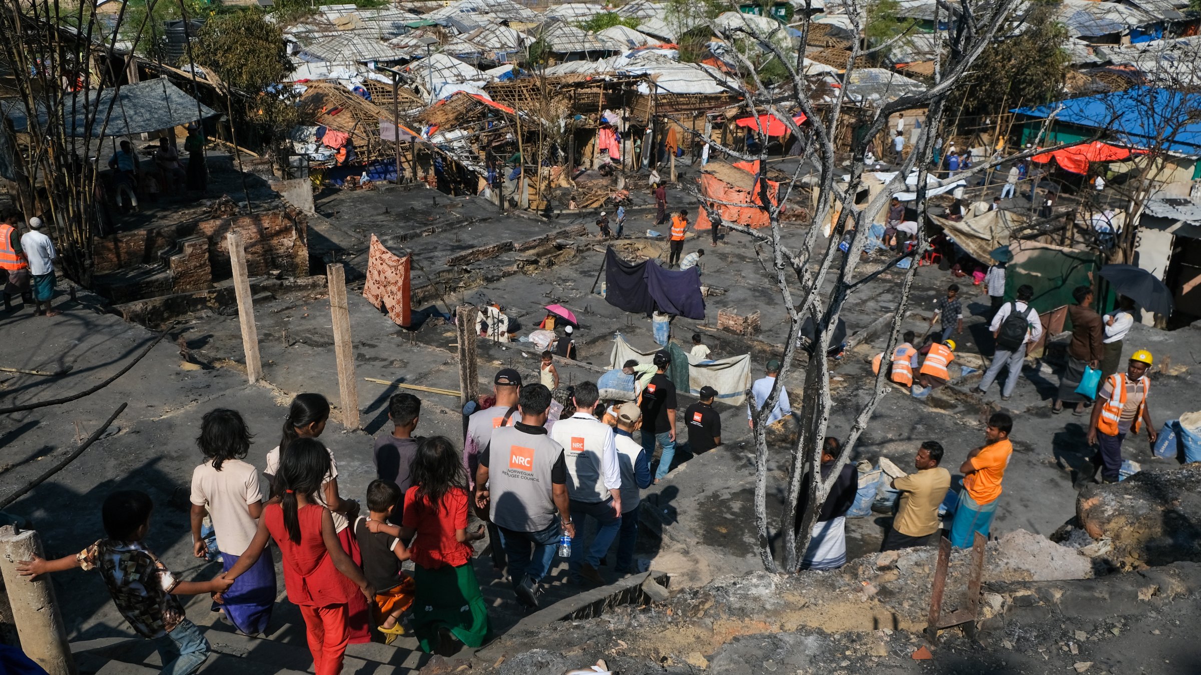 Children walk near the site of a fire that broke out in Camp 16, one of more than 30 Rohingya refugee camps in the Cox's Bazar district, Bangladesh, Tuesday, Jan. 20, 2026. (Ratul Piul, Norwegian Refugee Council via AP)
