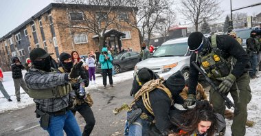 A person is detained by U.S. Border Patrol agents during a confrontation in an intersection, Minneapolis, U.S., Jan. 10, 2026. (AFP Photo)