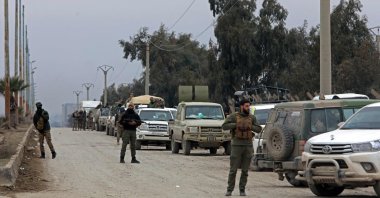 Members of Syrian government security forces stand guard along an area near to Al-Aqtan Prison on the outskirts of Raqqa, Syria, Jan. 22, 2026. (AFP Photo)
