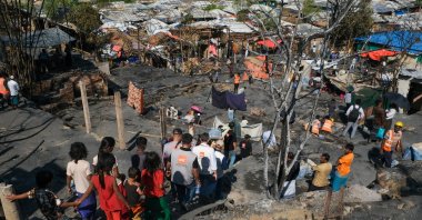 Children walk near the site of a fire that broke out in Camp 16, one of more than 30 Rohingya refugee camps in the Cox's Bazar district, Bangladesh, Tuesday, Jan. 20, 2026. (Ratul Piul, Norwegian Refugee Council via AP)