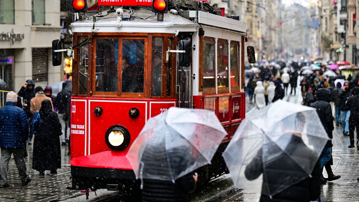 People walk through rainfall in Taksim Square as cold weather continues across the city, Istanbul, Türkiye, Jan. 18, 2026. (AA Photo) 