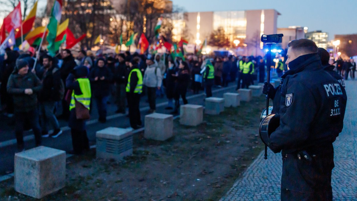 A police officer films pro-PKK/YPG protestors that walk in front of the Chancellery during a protest against the visit of Syrian President Ahmed Al Sharaa to Berlin, in Berlin, Germany, Jan. 19, 2026. (EPA Photo)