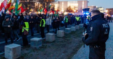 A police officer films pro-PKK/YPG protestors that walk in front of the Chancellery during a protest against the visit of Syrian President Ahmed Al Sharaa to Berlin, in Berlin, Germany, Jan. 19, 2026. (EPA Photo)