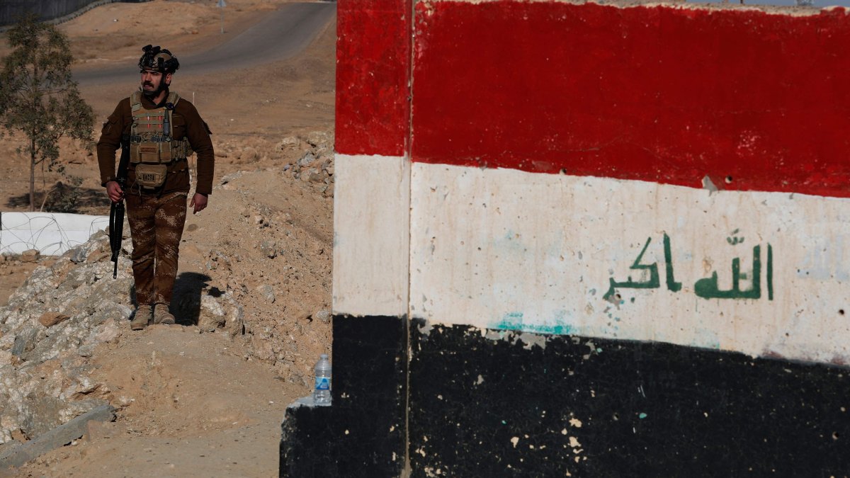 A member of the Iraqi border forces patrols along a concrete wall on the Iraqi-Syrian border, following recent events in Syria, in the town of al-Baghuz in the Al-Qaim district of western Iraq, Jan. 21, 2026. (AFP Photo)