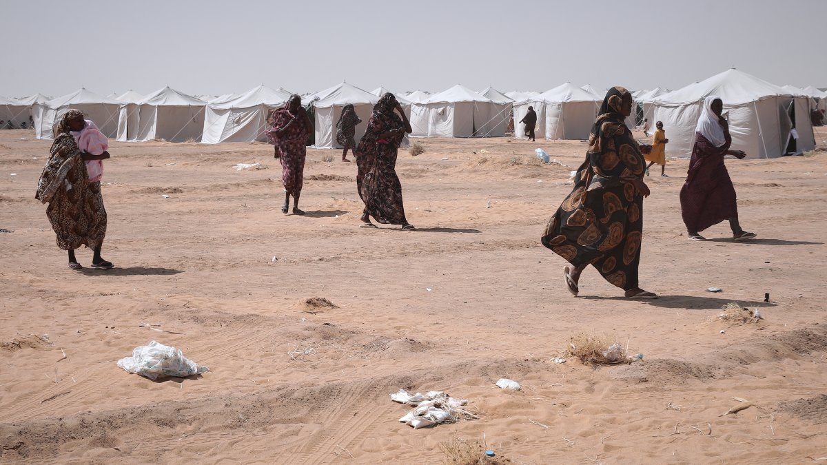 Sudanese women displaced from el-Fasher, the capital of North Darfur, and other conflict-affected areas walk through the newly established El-Afadh camp in Al-Dabbah, Northern State, Sudan, Nov. 13, 2025. (AP Photo)