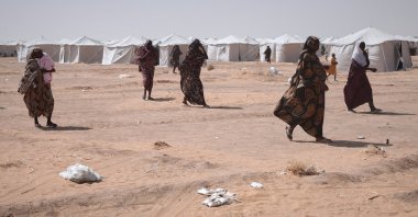 Sudanese women displaced from el-Fasher, the capital of North Darfur, and other conflict-affected areas walk through the newly established El-Afadh camp in Al-Dabbah, Northern State, Sudan, Nov. 13, 2025. (AP Photo)