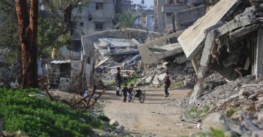 Palestinian children play with a wheelchair amid destroyed buildings in Khan Yunis, southern Gaza Strip, Palestine, Jan. 25, 2026. (AFP Photo)