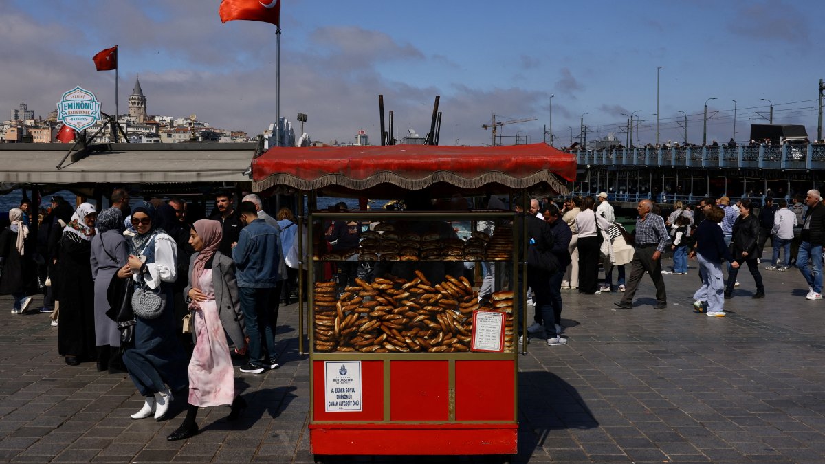 People walk as simit, a traditional Turkish bagel, is displayed at a stall for sale in Eminönü district, Istanbul, Türkiye, April 23, 2025. (Reuters Photo)