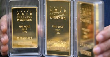 An employee displays gold bars at a store of the Korea Gold Exchange in Seoul, South Korea, Jan. 26, 2026. (AFP Photo)