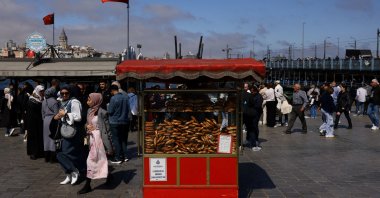 People walk as simit, a traditional Turkish bagel, is displayed at a stall for sale in Eminönü district, Istanbul, Türkiye, April 23, 2025. (Reuters Photo)