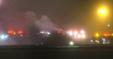 This image, taken from a video provided by WABI television, shows emergency services work on a scene of the Bombardier Challenger 600 crash at the Bangor Airport in Maine, Jan. 25, 2026. (AP Photo)