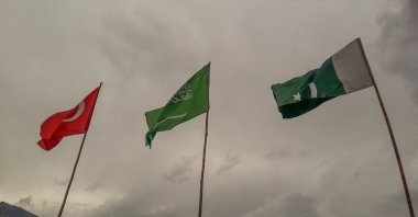 The flags of Türkiye, Saudi Arabia and Pakistan flutter against a backdrop of cloudy skies and mountainous terrain, Naran valley, Pakistan, July 13, 2024. (Shutterstock Photo)