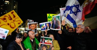 Demonstrators wave the pre-revolution lion and sun Iranian flags, Israeli flags and posters of the son of Iran's ousted Shah during a rally in support of Iran's anti-government protests, Holon, Israel, Jan. 14, 2026. (AP Photo)