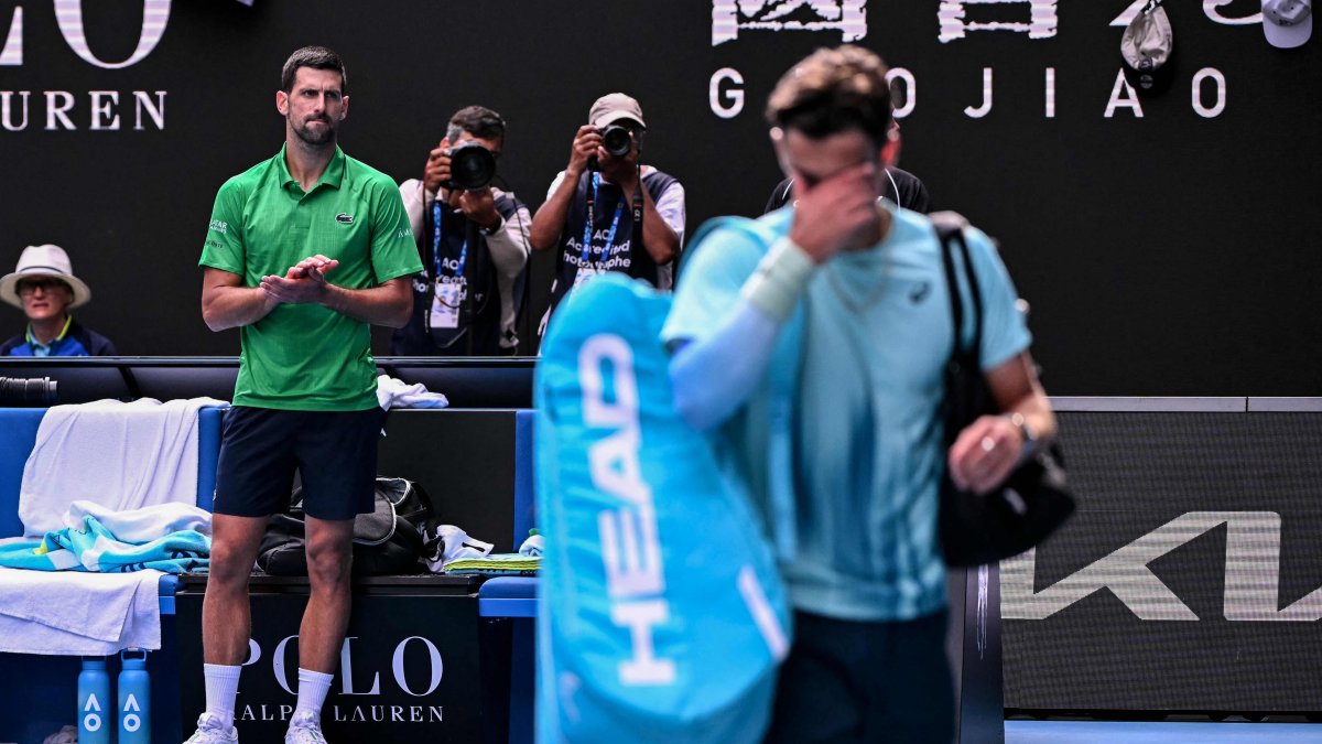 Serbia's Novak Djokovic (L) applauds as Italy's Lorenzo Musetti (R) walks off the court after retiring from their men's singles quarter-final match on day eleven of the Australian Open tennis tournament, Melbourne, Australia, Jan. 28, 2026. (AFP Photo)