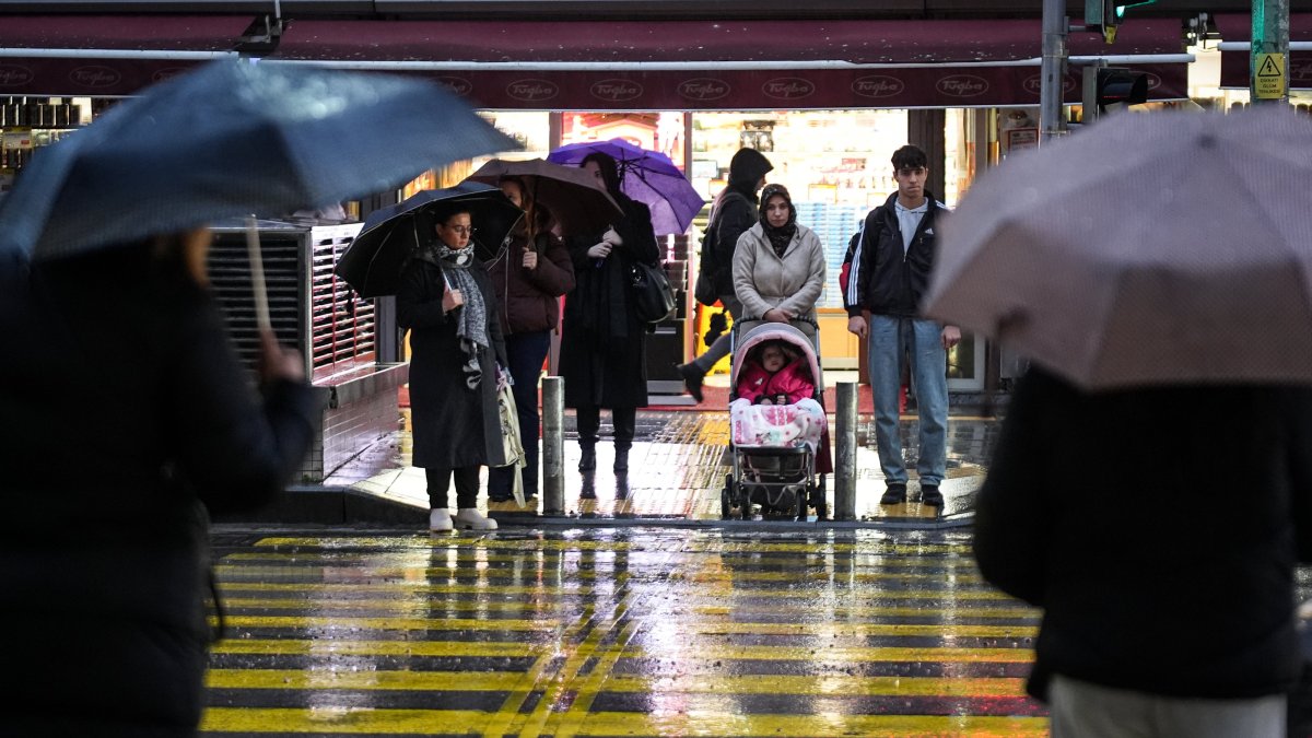 People wait at a crosswalk during a rainfall, Izmir, western Türkiye, Jan. 22, 2026. (AA Photo)
