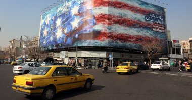  Vehicles drive near a huge anti-U.S. billboard hanging at the Enqelab square in Tehran, Iran, Jan. 27, 2026. (EPA Photo)
