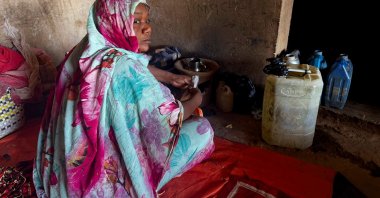 A displaced woman places a tea pot on a clay stove in El-Obeid, Kordofan, Sudan, Jan. 15, 2026. (Reuters Photo)