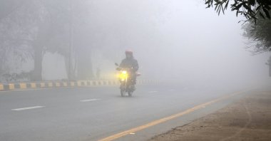 A motorcycle rider drives down a road amid heavy fog, Lahore, Pakistan, Jan. 17, 2026. (EPA Photo)