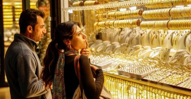 People look at gold jewelry as they stand outside a jewellery shop at the Grand Bazaar, Istanbul, Türkiye, Jan. 26, 2026. (Reuters Photo)