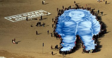 People participate in an action on a beach to remember Hind Rajab (depicted on large figure), a Palestinian girl who died under Israeli fire along with her relatives in 2024, while waiting for emergency services, Barcelona, Spain, Jan. 29, 2026. (EPA Photo)