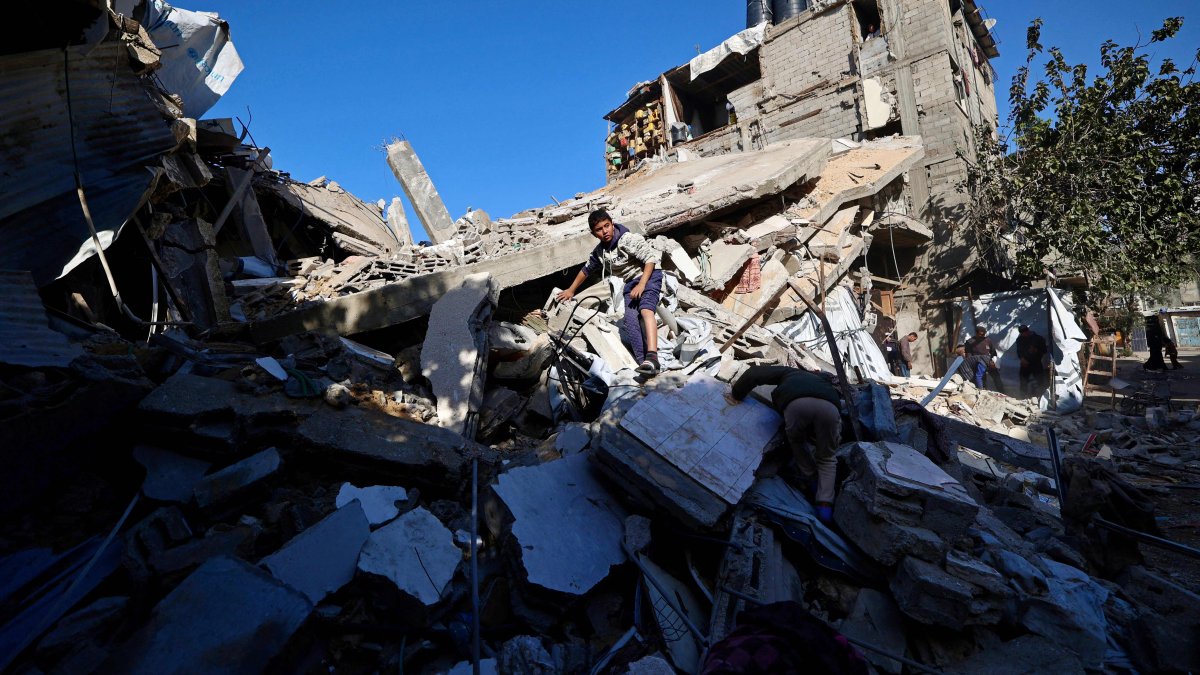 A Palestinian boy looks for his belongings amid the debris of a collapsed house that was previously damaged by an Israeli strike, at the Maghazi refugee camp, central Gaza, Palestine, Jan. 5, 2026. (AFP Photo)