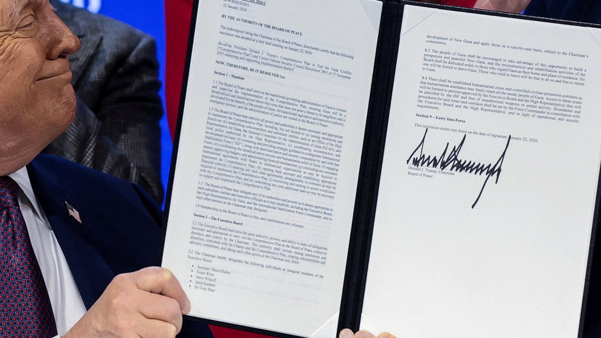 U.S. President Donald Trump holds a signed resolution, as he attends a charter announcement for his Board of Peace initiative, Davos, Switzerland, Jan. 22, 2026. (Reuters Photo)