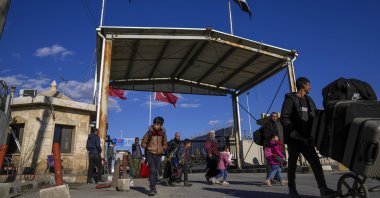 Syrians cross the border from Türkiye into Syria at the Bab al-Salama crossing gate, Syria, Dec. 13, 2024. (AP Photo)