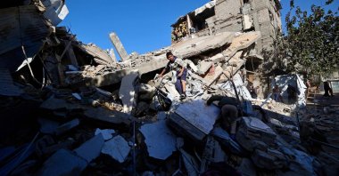 A Palestinian boy looks for his belongings amid the debris of a collapsed house that was previously damaged by an Israeli strike, at the Maghazi refugee camp, central Gaza, Palestine, Jan. 5, 2026. (AFP Photo)