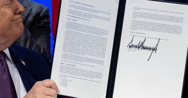 U.S. President Donald Trump holds a signed resolution, as he attends a charter announcement for his Board of Peace initiative, Davos, Switzerland, Jan. 22, 2026. (Reuters Photo)