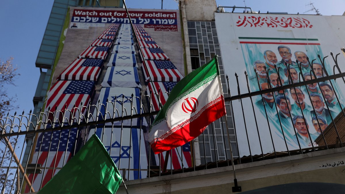 A billboard with anti-U.S. and anti-Israeli message is displayed on a building with a Iranian flag fluttering in front of it on a street in Tehran, Iran, Jan. 31, 2026. (Reuters Photo)
