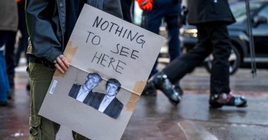 A protester holds a placard displaying photographs depicting Jeffrey Epstein (L), a wealthy U.S. financier who died in jail in 2019 while awaiting trial for sex trafficking underage girls and U.S. President Donald Trump (R) while taking part in a demonstration against the World Economic Forum (WEF) on the eve of the WEF annual meeting in Davos, Switzerland, Jan. 18, 2026. (AFP Photo)