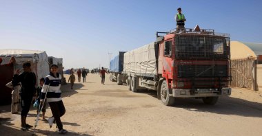 Palestinians look on as trucks carrying humanitarian aid arrive in Khan Yunis in the southern Gaza Strip, after passing through the Rafah border crossing from Egypt, on Feb. 1, 2026. (AFP Photo)